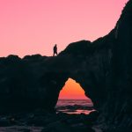 silhouette of man on rock walking during nightime