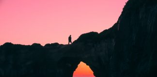 silhouette of man on rock walking during nightime
